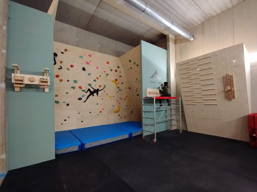 Overzicht van de afgewerkte bouldergym met klimwand, campusboard en trainingszone