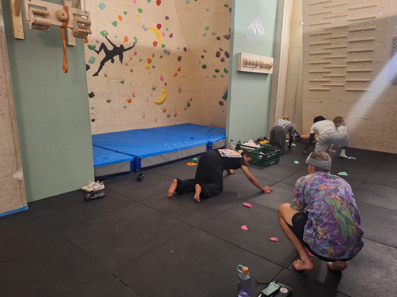 IMG-20260812-WA0003 Deelnemers sorteren klimgrepen op de vloer van de boulderzaal tijdens de opleiding boulderen