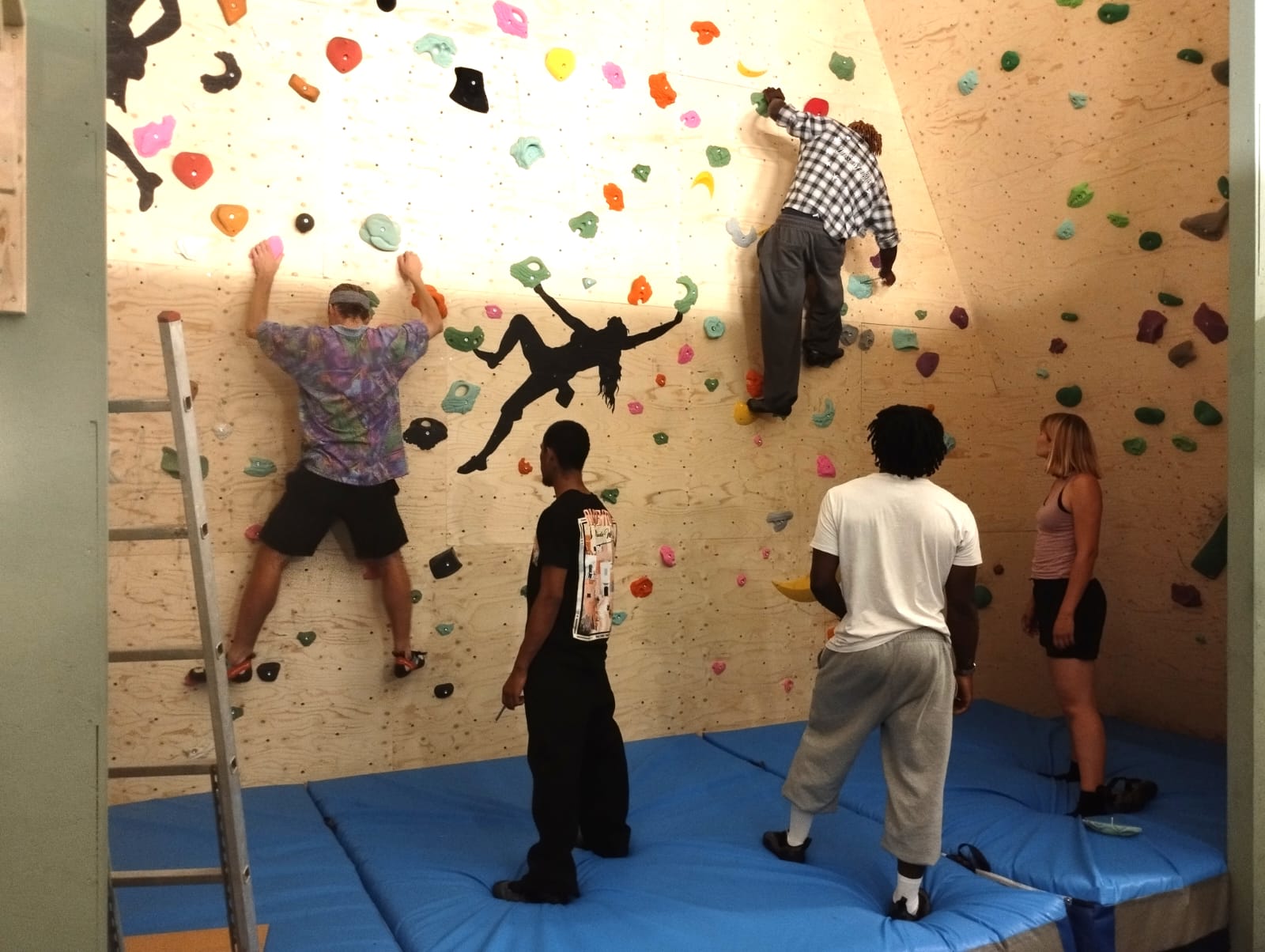 IMG-20260812-WA0008 Groep deelnemers oefent klimtechniek op de overhangende bouldermuur tijdens de opleiding