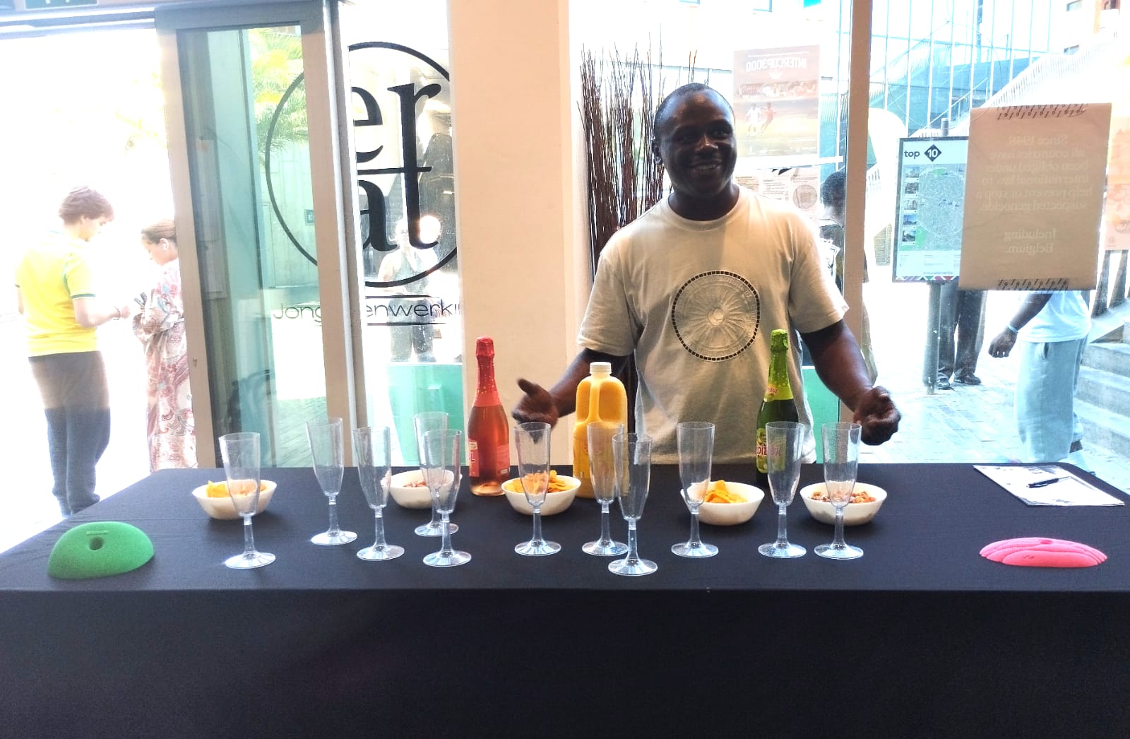 IMG-20260812-WA0009 Begeleider achter een tafel met drankjes bij de afsluiting van de opleiding bij VZW Erat